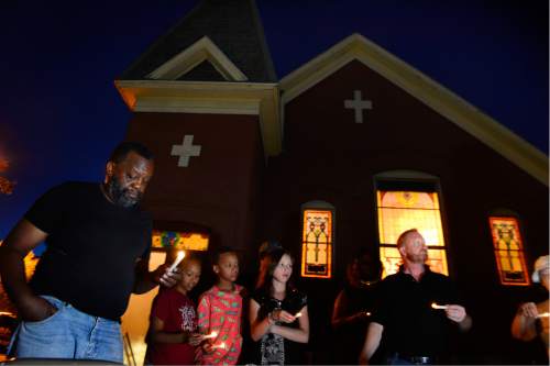 Scott Sommerdorf  |  The Salt Lake Tribune  
Lee Johnson, left, and other members of the Trinity African Methodist Episcopal Church hold nine candles to honor the nine victims killed at the Emanuel AME Church in Charleston, S.C., a year ago. The small group held the candlelight vigil outside the Salt Lake City church, Friday, June 17, 2016.
