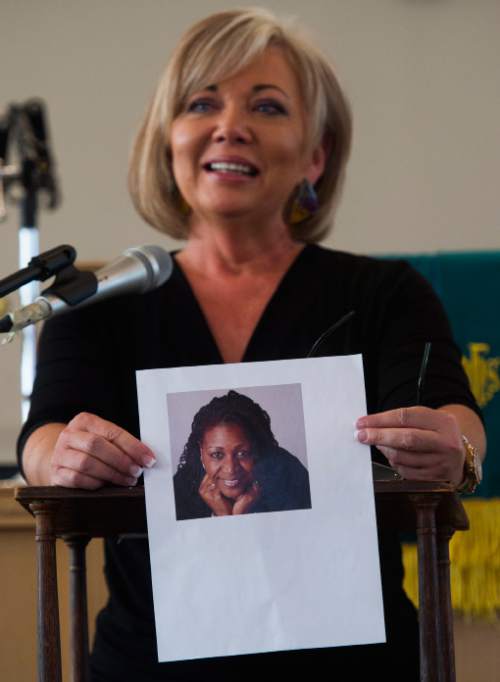 Steve Griffin / The Salt Lake Tribune

Kathy Morris holds a picture of Rev. Depayne Middleton-Doctor, who was one of the Charleston 9, gunned down a year ago at Emanuel AME Church in South Carolina,  during a program at Trinity AME Church in Salt Lake City Sunday June 19, 2016. Church members recalled the good works and character of each of the Charleston 9 at the memorial program.