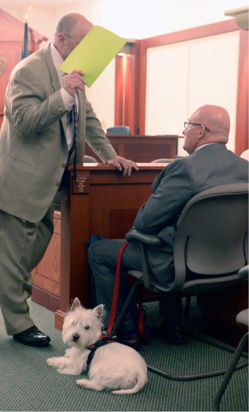 Al Hartmann  |  The Salt Lake Tribune
Timothy Lawson, right, dubbed a "fixer" for former Utah Attorney General Mark Shurtleff speaks to his defense lawyer Ron Yengich in Judge Katie Bernards-Goodman's courtroom in Salt Lake City Monday April 25.  His service dog Prince at his side. 
Lawson is charged with six felonies -- including counts of tax evasion, witness tampering, obstruction of justice and a pattern of unlawful conduct -- stemming from allegations that he attempted to intimidate or threaten individuals with ties to Shurtleff and his successor, John Swallow.