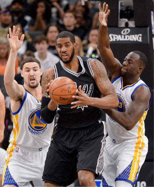 San Antonio Spurs forward LaMarcus Aldridge, center, tangles with Golden State Warriors' Klay Thompson, left, and Draymond Green during the first half of an NBA basketball game, Sunday, April 10, 2016, in San Antonio. Golden State won 92-86. (AP Photo/Darren Abate)