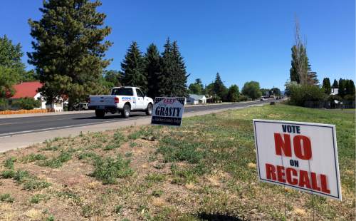 In this June 21, 2016 photo, signs in Burns, Ore.,  urge voters to keep Harney County Judge Steve Grasty. Activists who didn't like the way he treated armed occupiers of a federal wildlife refuge want him recalled in a June 28 recall election. Grasty sees this election as a referendum on the county's handling of the crisis. Winter and spring have passed since an armed occupation of a federal wildlife refuge ended, but its aftershocks are still shaking this high desert region. (AP Photo/Andrew Selsky)