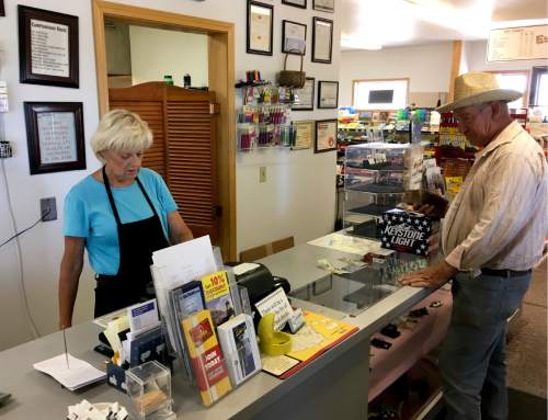 In this June 21, 2016 photo, Linda Gainer, co-owner of The Narrows, a cafe, saloon, shop and gas station near the Malheur National Wildlife Refuge near Burns, Ore., attends to a customer. Winter and spring have passed since an armed occupation of a federal wildlife refuge ended in Oregon, but aftershocks of the takeover are still hitting this high desert region. (AP Photo/Andrew Selsky)