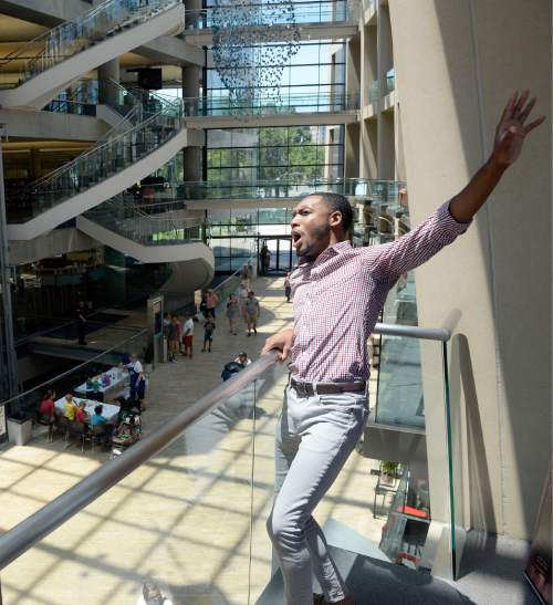 Al Hartmann  |  The Salt Lake Tribune 
Markel Reed, a baritone with Utah Opera, sings his finale from a high balcony in a "pop-up" performance in the atrium of City Library Thursday June 23, the first afternoon of the Utah Arts Festival.  
"Random acts" of art, like this performance happen away from the traditional stages at the Utah Arts Festival.