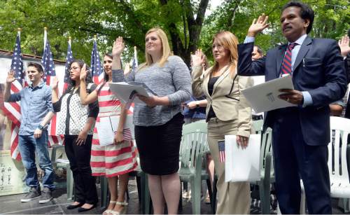 Al Hartmann  |  The Salt Lake Tribune 
Sixteen people raise their hands to be sworn in as new U.S. citizens in a naturalization ceremony Friday July 1 at the Freedom Festival in Scera Park in Orem.  They are from Austrailia, Brazil, Canada, Ecuador, El Salvador, Honduras, Mexico, South Africa, India and the United Kingdom.