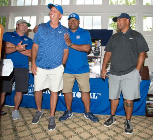 Steve Griffin / The Salt Lake Tribune

After singing the University of Utah fight song BYU football offensive coordinator Ty Detmer laughs as he gets a hug from head coach Kalani Sitake following the rivalry for charity (National Kidney Foundation) golf tournament at Hidden Valley Country Club in Sandy, Utah Monday June 13, 2016. Deter confessed he didn't know the U o U fight song and admitted he couldn't remember the BYU fight song either. Sitake came to his defense saying he is more interested in Detmer's ability to teach the Cougar quarterbacks than in his singing. The tournament pitted the Utah football team coaches against the BYU football coaches with the losing team singing the others fight song. Sitake and his team held up their end of the bargain and sang the fight song after falling to the Utah coaches in the tournament.