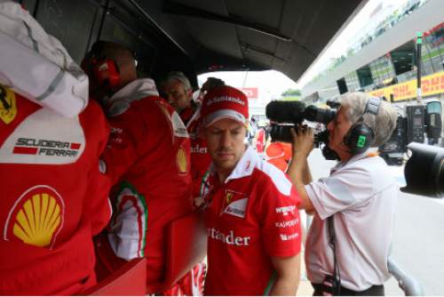 Ferrari driver Sebastian Vettel of Germany stands at the Ferrari pits after failing to complete the Austrian Formula One Grand Prix at the Red Bull Ring racetrack, in Spielberg, southern Austria, Sunday, July 3, 2016. (AP Photo/Ronald Zak, Pool)