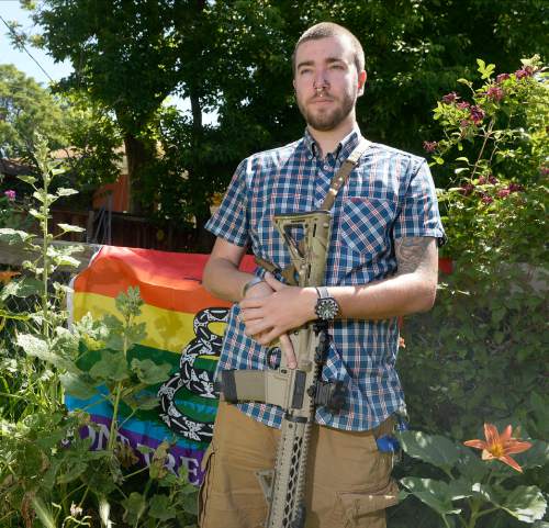 Al Hartmann  |  The Salt Lake Tribune
Matt Schlentz poses with his Rainbow-Gadsen Flag and AR-15 in his backyard in Salt Lake City,  Wed. June 16. He is with Pink Pistols, a pro-gun-rights LGBT organization.