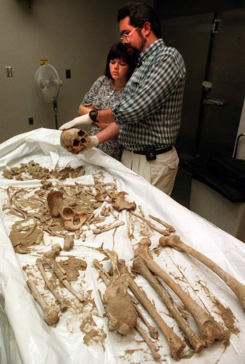 Tribune file photo
Dr. Todd Grey of the State Medical Examiner's Office points out to his assistant, Helen Wilson ,characteristics  of a skull that could determine the person's sex.