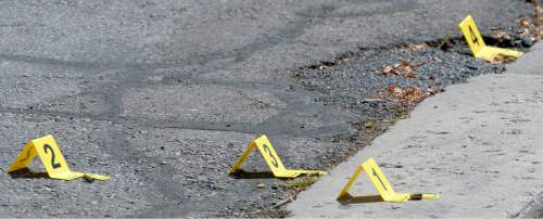 Al Hartmann  |  The Salt Lake Tribune 
Salt Lake City police markers near shell casings at the of a scene of a drive-by shooting Wednesday, July 6, 2016. One person was injured in the shooting at the City Park apartment complex parking area -- at 750 N. 900 West -- and transported to the hospital.