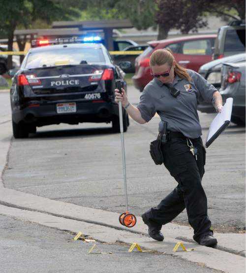 Al Hartmann  |  The Salt Lake Tribune 
A Salt Lake City police investigator steps around markers of shell casings at the scene of a drive-by shootingWednesday, July 6, 2016 at City Park apartment complex parking area at 750 N. 900 West.  One person was injured and transported to the hospital.