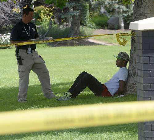 Al Hartmann  |  The Salt Lake Tribune 
A Salt Lake City police offiver interviews a witness at the scene of a drive-by shooting Wednesday, July 6, 2016 at City Park apartment complex parking area at 750 N. 900 West.  One person was injured and transported to the hospital.