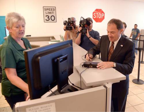 Al Hartmann  |  The Salt Lake Tribune 
Utah Gov. Gary Herbert checks in with hearing officer Kathy Main at the Fairpark Drivers Licensce office in Salt Lake City Monday July 11 to renew his drivers license.  He is one of the first to obtain the new, more secure card the state is now issuing.