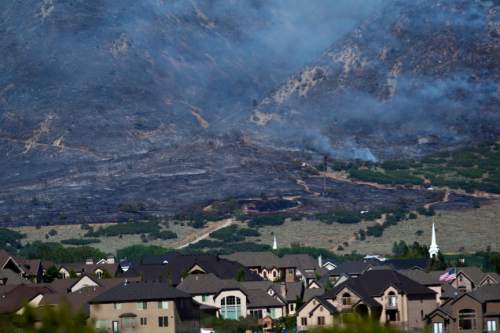 Chris Detrick  |  The Salt Lake Tribune

The Quail fire burns above Alpine Tuesday July 3, 2012. A wildfire that started about 2 p.m. Tuesday in Lambert Park in Alpine has burned at least one structure -- a barn -- and 80 homes have been evacuated, according to the Lone Peak Police Department. Utah County Sheriff's Sgt. Spencer Cannon said the fire was human-caused -- somehow sparked by a man was working on a trackhoe near the Alpine rodeo grounds.