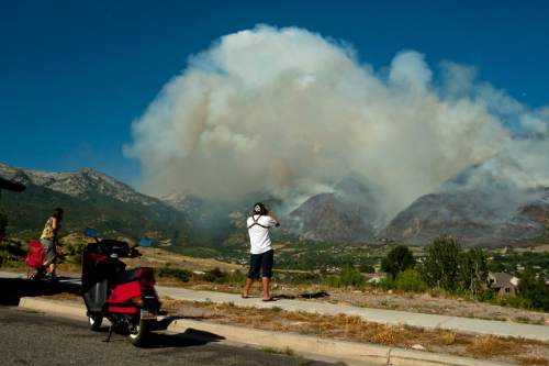 Chris Detrick  |  The Salt Lake Tribune

Residents watch as the Quail fire burns above Alpine Tuesday July 3, 2012. A wildfire that started about 2 p.m. Tuesday in Lambert Park in Alpine has burned at least one structure -- a barn -- and 80 homes have been evacuated, according to the Lone Peak Police Department. Utah County Sheriff's Sgt. Spencer Cannon said the fire was human-caused -- somehow sparked by a man was working on a trackhoe near the Alpine rodeo grounds.