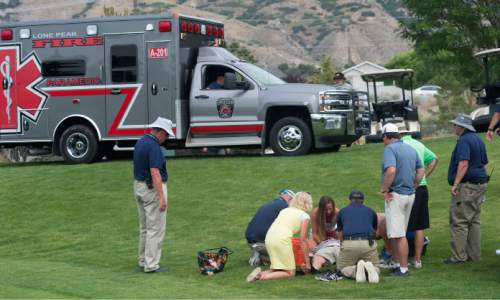 Steve Griffin / The Salt Lake Tribune

 An ambulance arrives at the 11th green as Aaron Smith is assisted by his wife and tournament officials after he  collapsed and couldn't continue after the 11th hole of his semifinal match in the 118th annual Utah State Amateur golf tournament at Alpine Country Club in Alpine, Utah Friday July 15, 2016. Smith laid down on the grass after putting out on the hole complaining of back spasms and exhaustion and was taken to the hospital by ambulance. Smith was ahead of Kyler Dearden in the match at that point.