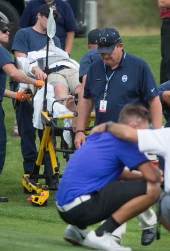 Steve Griffin / The Salt Lake Tribune

A shaken Kyler Dearden, front, is consoled as his opponent  Aaron Smith is taken from the golf course by ambulance after Smith collapsed and couldn't continue after the 11th hole of his semifinal match in the 118th annual Utah State Amateur golf tournament at Alpine Country Club in Alpine, Utah Friday July 15, 2016. Smith laid down on the grass after putting out on the hole complaining of back spasms and exhaustion and was taken to the hospital by ambulance. Smith was up in the match at that point.