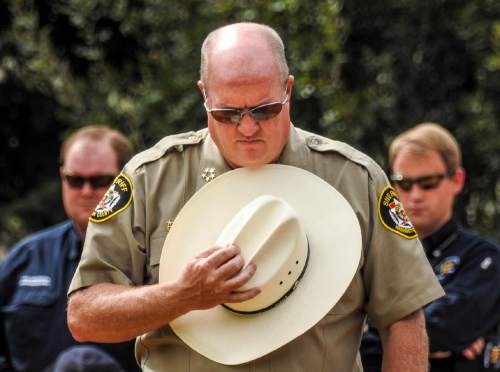 Trent Nelson  |  The Salt Lake Tribune
Washington County Sheriff Cory Pulsipher bows his head at a memorial for the victims of a Sept. 14 flash flood. The memorial was held in Maxwell Park in Hildale, Saturday Sept. 26, 2015.