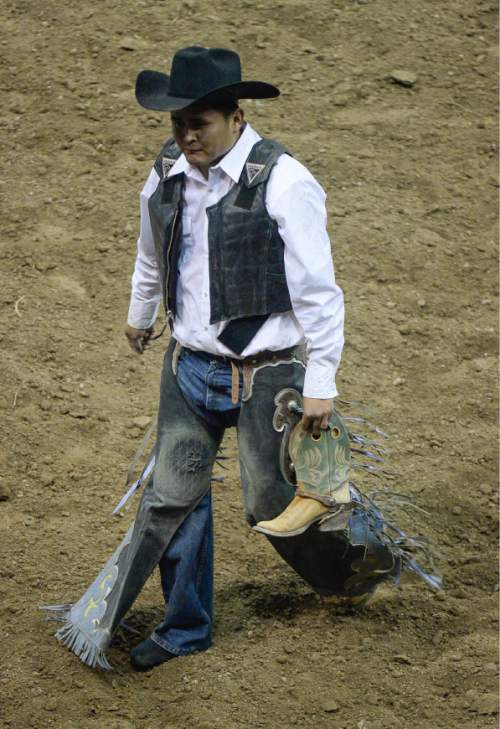 Francisco Kjolseth | The Salt Lake Tribune
Paul Llewellyn of Tohatchi, NM, carries his cowboy boot following a short ride during the saddle bronc competition on day three to the Days of '47 Rodeo, at Vivint Arena, Thursday, July 21, 2016.