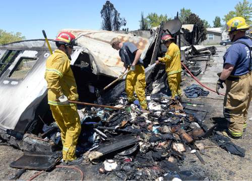 Al Hartmann  |  The Salt Lake Tribune 
Firefighters work to put out hot spots in a burned out neighborhood in Tooele, Utah, on Wednesday, July 20, 2016. Wind whipped up a grass fire that eventually destroyed 10 homes.