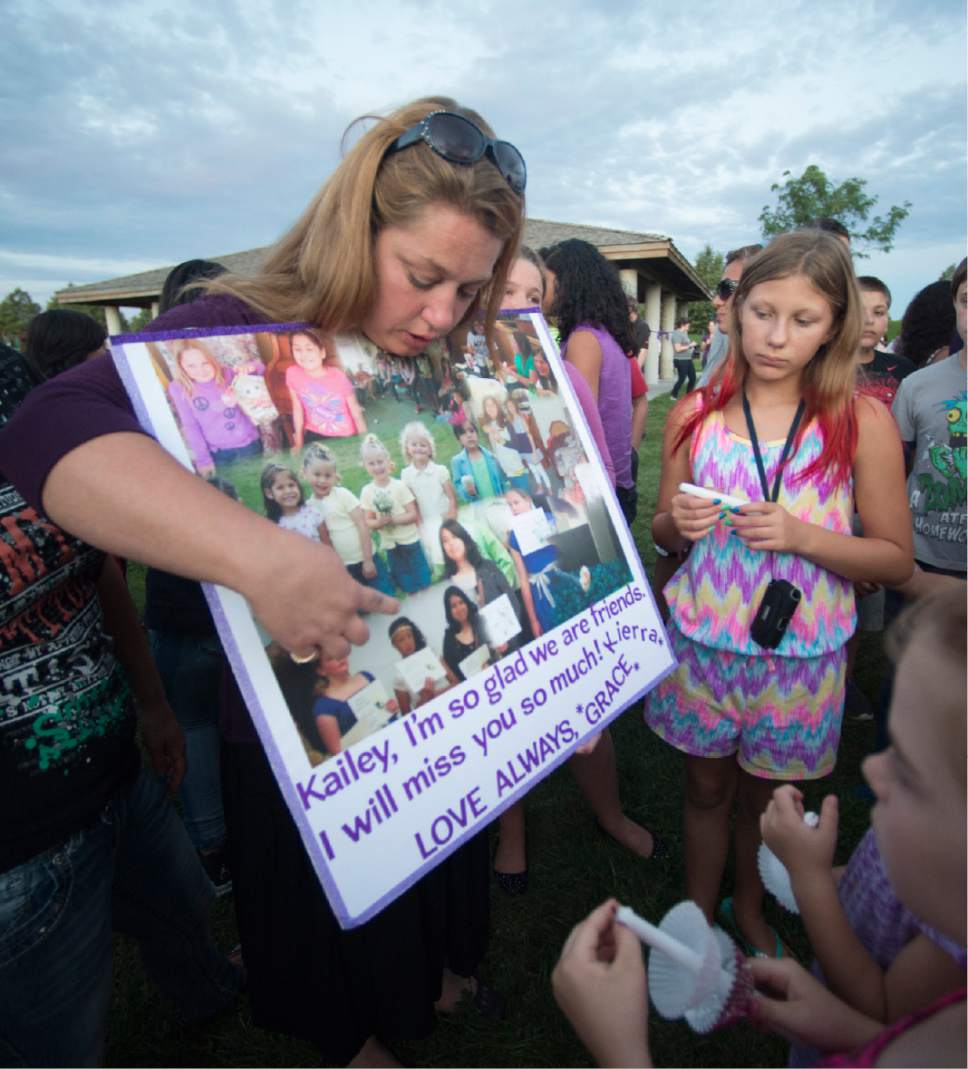 Rick Egan  |  The Salt Lake Tribune

Mamie Kynaston shows a collage of pictures of Kailey from grade school, as friends and family of Kailey Vijil gather for a candle light vigil, in memory of the 12-year-old West Valley City girl who died earlier this week, Sunday, July 19, 2015.