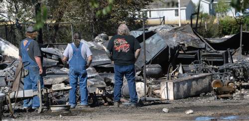 Al Hartmann  |  The Salt Lake Tribune 
Tooele residents survey damage at a burned out neighborhood on Wednesday, July 20, 2016. Wind whipped up a grass fire that eventually destroyed 10 homes.