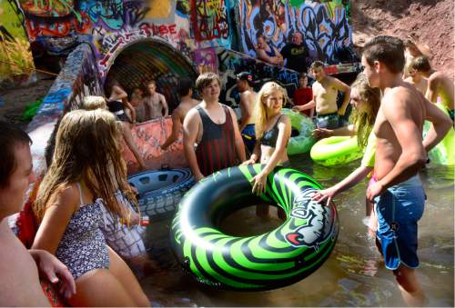 Scott Sommerdorf   |  The Salt Lake Tribune  
Tubers in foreground wait their turn to "shoot the tube" as others already in the tube are next to float down once the built up water is released down the tube, near Tanner Park on Friday.