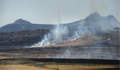 Scott Sommerdorf   |  The Salt Lake Tribune  
As a "fire whirl" spins in the foreground, some of the hundreds of acres of burnt land can be seen on Antelope Island on Saturday.