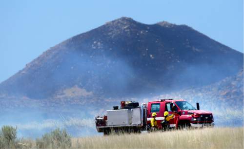 Scott Sommerdorf   |  The Salt Lake Tribune  
Firefighters work to solidify a line that can be protected just on the other side of the road from the historic Fielding Garr Ranch on Antelope Island, Saturday, July 23, 2016.
