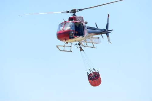 Scott Sommerdorf   |  The Salt Lake Tribune  
A firefighting helicopter heads to a hotspot after filling up it's bucket on Antelope Island, Saturday, July 23, 2016.