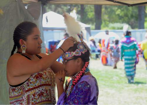 Al Hartmann  |  The Salt Lake Tribune 
Kassie John, left, from Rockpoint, AZ helps her niece Catanya Castillo from Ann Arbor Michigan with her hair before she dances at the annual Native American Celebration at Liberty Park July 25.