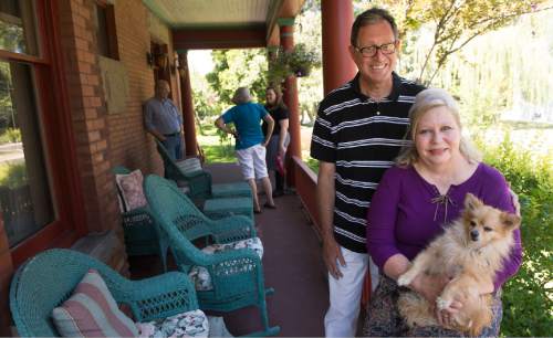 Leah Hogsten  |  The Salt Lake Tribune
Tino and Rebecca Santa Cruz, holding their dog, Gus,  welcomed Murray Pioneer Home Tour visitors to their home, formerly owned by  Wesley and Frances Walton (circa 1899). The brick Victorian Eclectic house is situated on a portion of an original 160 acre homestead owned by the Huffaker pioneer family.