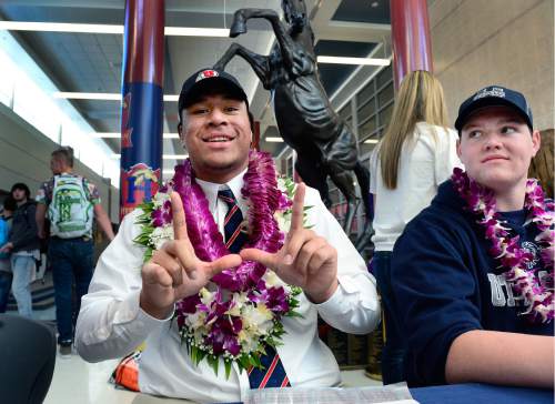 Scott Sommerdorf   |  The Salt Lake Tribune
Herriman defensive end Leki Fotu, left, flashes a "U" after he announced that he's committed to play football at the University of Utah, Wednesday, February 3, 2016. At right is team mate Ty Shaw, (OL), who committed to Utah State.