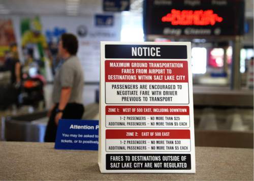 Scott Sommerdorf   |  The Salt Lake Tribune  
A sign sits atop the luggage carousel at the Salt Lake City International Airport warning travelers to negotiate their fare with taxi drivers, Wednesday, July 20, 2016.  There have been some complaints of price gouging after deregulation of taxis and ride-hailing companies has created a sort of Wild West atmosphere in the industry.