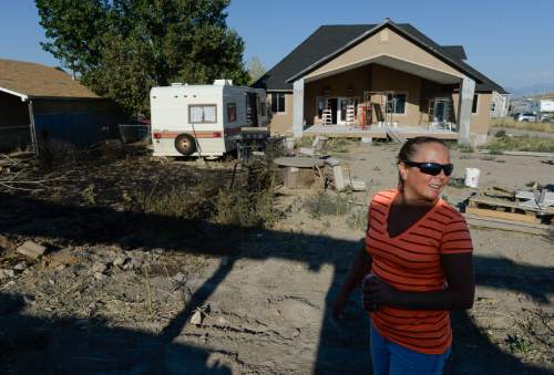 Francisco Kjolseth | The Salt Lake Tribune
Sitting in her temporary trailer home eating ice cream on Thursday afternoon, Jeanne Johnson feels lucky the fire that started with a loud bang didn't do more damage or burn down her house under construction in the background. She says it sounded like "an M80 type firework and my neighbors lit it off." The fire located near 13752 S. 7300 W. had the potential to get much worse if not quickly contained by United Fire Authority.