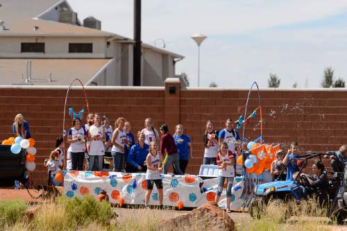 Trent Nelson  |  The Salt Lake Tribune
Students riding a float representing Snow Canyon High School launch a water fight during the Colorado City and Hildale Fourth of July Parade in Hildale, UT, and Colorado City, AZ, Saturday July 2, 2016. At rear behind a large wall is the Leroy S. Johnson meetinghouse, used by the Warren Jeffs led FLDS Church.