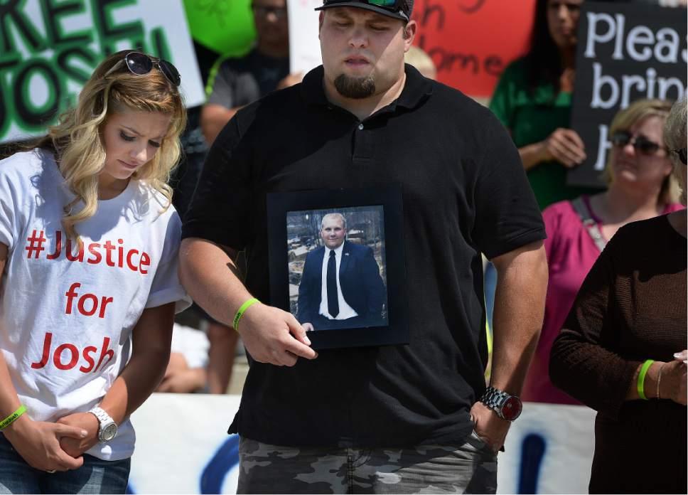 Scott Sommerdorf   |  The Salt Lake Tribune  
Josh Holt's brother Derek Holt holds a photo of Josh with sister Jenna at left during a rally on the east steps of the Utah State Capitol for 24-year-old Josh Holt, who is currently jailed in Venezuela on Saturday.
