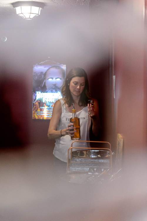 Trent Nelson  |  The Salt Lake Tribune
Brooke Wadman pours a sample for tasting, seen through a Zion Curtain at Ogden's Own Distillery in Ogden, Friday July 15, 2016. Utah distilleries must now have a Zion Curtain, to keep minors from seeing adults taste; distilleries also must offer "substantial food" to tasters who may want it.