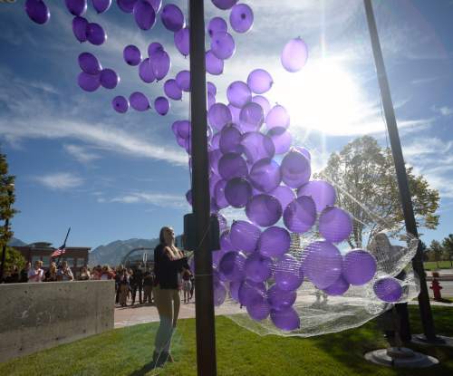 Al Hartmann  |   Tribune file photo
In honor of Domestic Violence Month, This October 2014 photo shows 272 purple balloons being released representing victms of domestic violence in Sandy the previous year. The event was part of Domestic Violence Month, aimed at raising awareness of the problem.