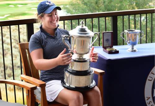 Scott Sommerdorf   |  The Salt Lake Tribune  
Kendra Dalton beams at the Utah Women's State Amateur golf tournament's perpetual trophy after her win at the 2016 Utah Women's State Amateur golf tournament over Lea Garner - both of BYU - at Victory Ranch Golf Club in Francis, Friday, August 5, 2016. Dalton gets to take home the smaller trophy at the far right.