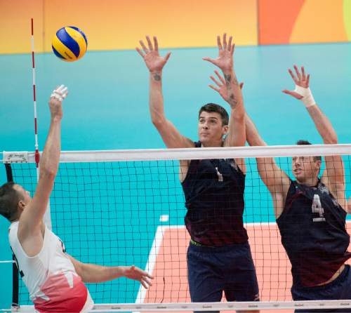 Rick Egan  |  The Salt Lake Tribune

Gavin Schmitt (12) of Canada hits the ball, as Matthew Anderson (1) and David Lee (4) defend for the United States, in Men's Olympic volleyball action at Ginásio do Maracanãzinho, in Rio de Janeiro, Sunday, August 7, 2016.