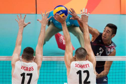 Rick Egan  |  The Salt Lake Tribune

Taylor Sander (3) of United States, hits the ball past Graham Vigrass (17) and Gavin Schmitt (12) of Canada, in Men's Olympic volleyball action at Ginásio do Maracanãzinho, in Rio de Janeiro, Sunday, August 7, 2016.