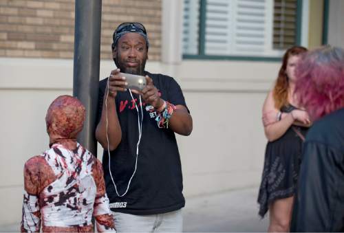 Lennie Mahler  |  The Salt Lake Tribune

Amlak Tafari, a member of the band Steel Pulse in town from England, watches zombies take to the streets in the 9th annual SLC Zombie Walk in downtown Salt Lake City, Sunday, Aug. 7, 2016.