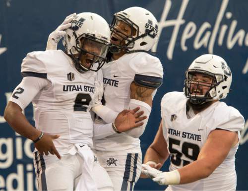 Rick Egan  |  The Salt Lake Tribune

Utah State quarterback Kent Myers (2) is joined by wide receiver Brandon Swindall (11), Aggies center Austin Stephens (59), after Myers ran for a touchdown, in college football action, Utah State vs Colorado State at Maverik Stadium in Logan, Saturday, October 3, 2015.
