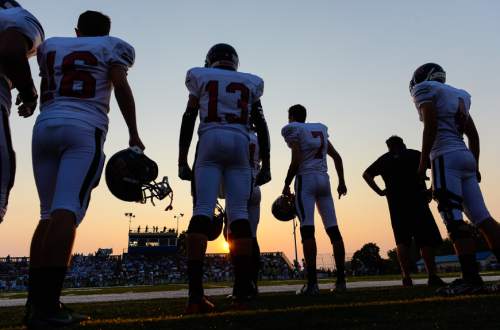 Francisco Kjolseth | The Salt Lake Tribune
The sun sets on a smoky sky as Hurricane players wait their turn to battle Skyline during the season opener at Skyline on Thursday, Aug. 20, 2015.