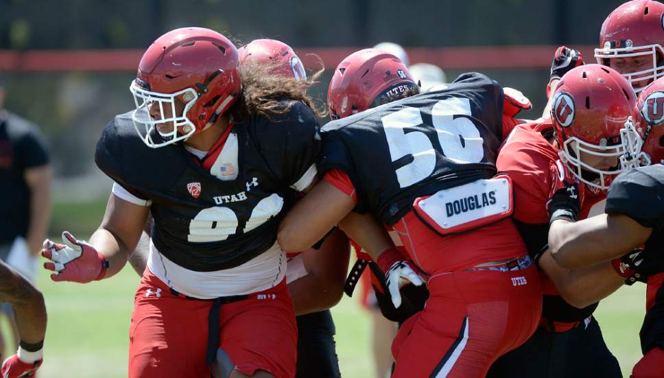 Al Hartmann  |  The Salt Lake Tribune 
Keji Fotu, left, and Bradlee Aane, 56, lock arms and hold the line during practice on Tuesday Aug 9.  They are two of the three Ute freshmen defensive linemen with talent and promise.
