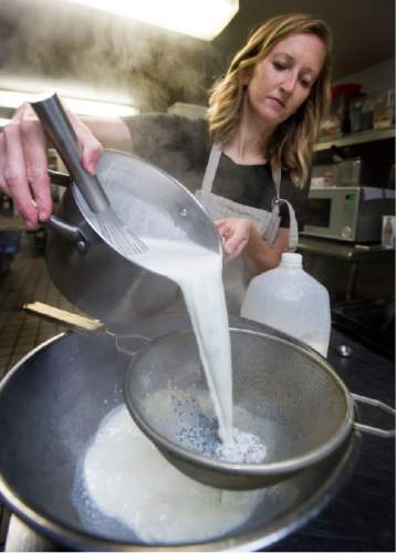 Steve Griffin | The Salt Lake Tribune

Jolene Hale, owner of Milk Honey Fine Yogurt, pours a pan of hot milk and lavender blossoms through a strainer as she makes and bottles her homemade product to sell at Salt Lake City's Downtown Farmers Market. She bottles the yogurt at Enlightened Bakery in Provo.