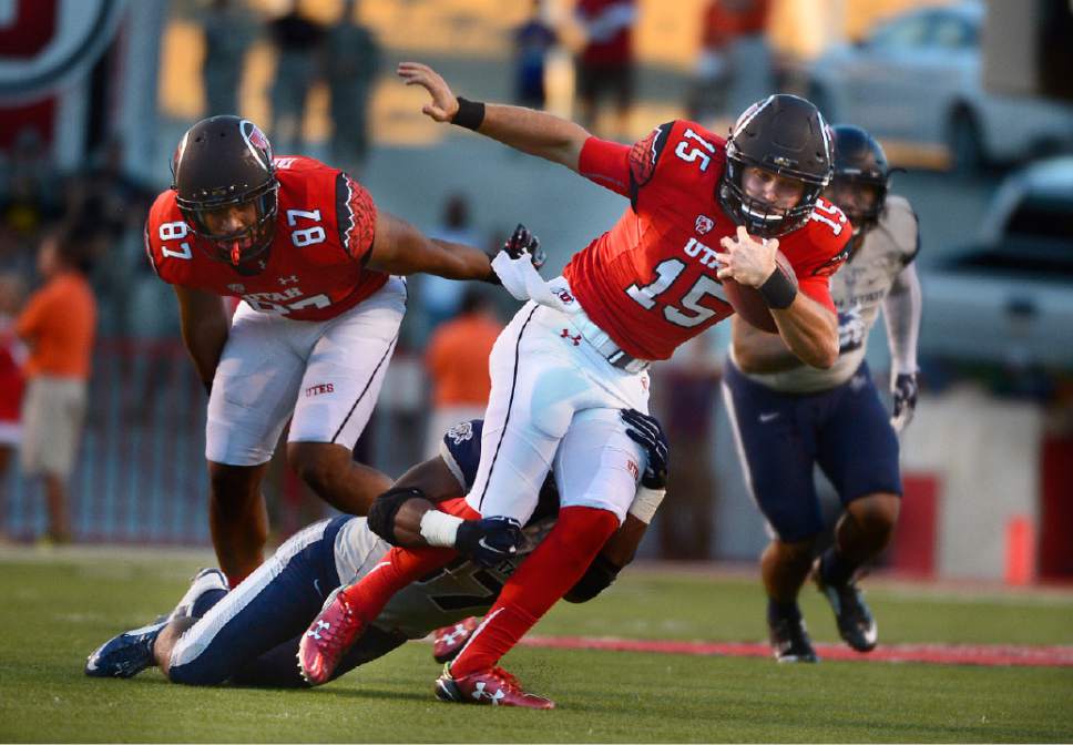 In this Sept. 11, 2015 photo, Utah quarterback Chase Hansen runs with the ball against Utah State at Rice-Eccles Stadium in Salt Lake City. Freshman Chase Hansen is the quarterback of the future for No. 3 Utah, but in the meanwhile, he's switched jerseys and sides of the ball.  (Scott Sommerdorf/The Salt Lake Tribune via AP) DESERET NEWS OUT; LOCAL TELEVISION OUT; MAGS OUT; MANDATORY CREDIT