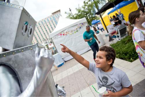 Lennie Mahler  |  The Salt Lake Tribune

Emilio Perez, 7, has an exchange with the Craft Lake City DIY Festival robot in downtown Salt Lake City on Saturday, Aug. 8, 2015. The festival, which features local arts, crafts, food vendors and live local music performances, takes place Aug. 12-14 for its eighth run this year.