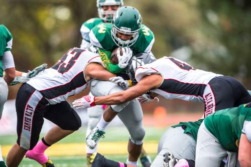 Chris Detrick  |  The Salt Lake Tribune
Kearns' Sione Finau (20) is tackled by Alta's Dante kalil Leota-hunkin (53) and Alta's MJ Tafisi (4) during the game at Kearns High School Friday October 30, 2015.