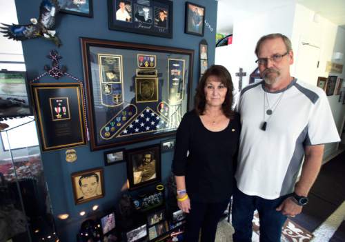 Steve Griffin / The Salt Lake Tribune

Keno and Sam Day stand next to a memorial for their son Jared Day in their Taylorsville, Utah home Monday August 1, 2016. On Aug. 6, 2011, Taliban fighters shot down a Chinook helicopter carrying 38 military personnel, including 31 Americans ó the largest loss of U.S. life in the Afghanistan campaign ó and two Utahns:  Jared Day and Blanding's Jason Workman.